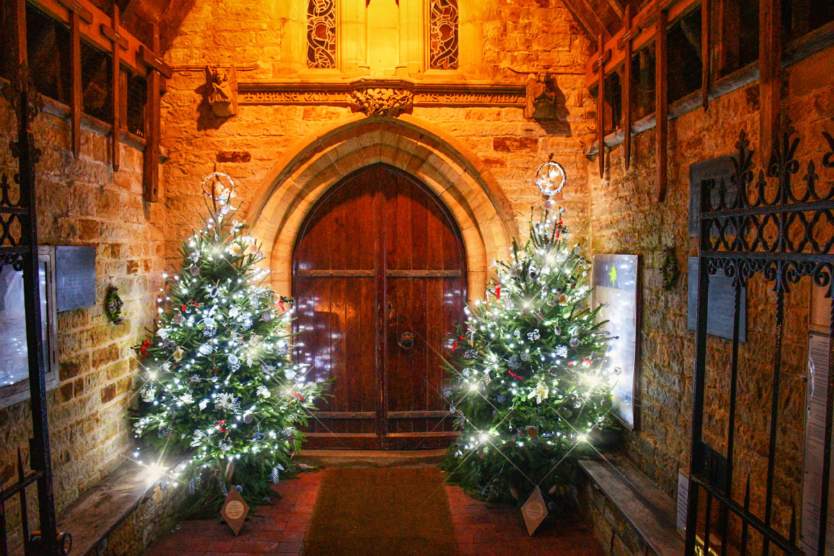 Sapins illuminés à l'entrée de l'église de Burwash (Angleterre) © French Moments