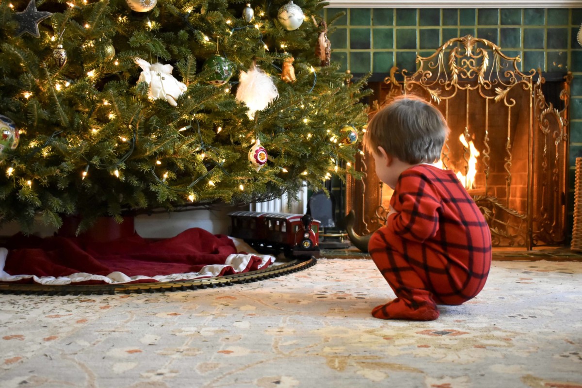 Un enfant attendant ses cadeaux au pied du sapin. Photo par @midwestphotographs via Twenty20